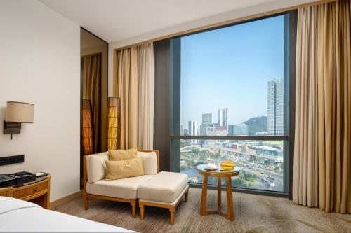 a hotel room with a chair and a large window at Dongguan Kande International Hotel in Dongguan