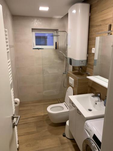 a bathroom with a toilet and a shower and a sink at Apartmani ORION - Sunce in Vinkovci