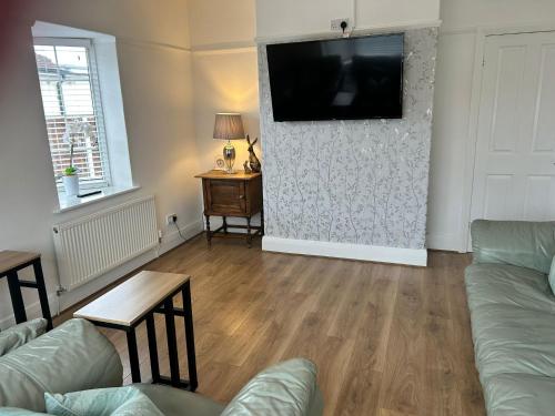 a living room with a flat screen tv on a wall at 3 bed bungalow Penrhyn Bay Llandudno in Llandrillo-yn-Rhôs
