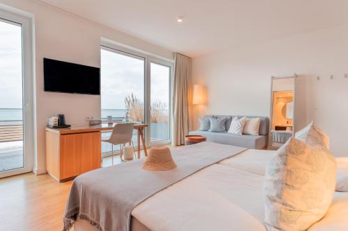 una camera da letto con un letto e una scrivania con una televisione di Hotel Strandhus a Cuxhaven