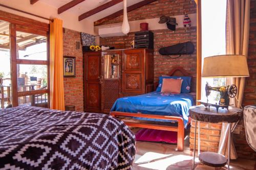 a bedroom with a bed and a brick wall at Cabaña Renacer in Samaipata
