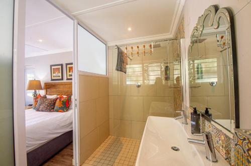 a bathroom with a shower and a sink at The Paper Fig House in Plettenberg Bay