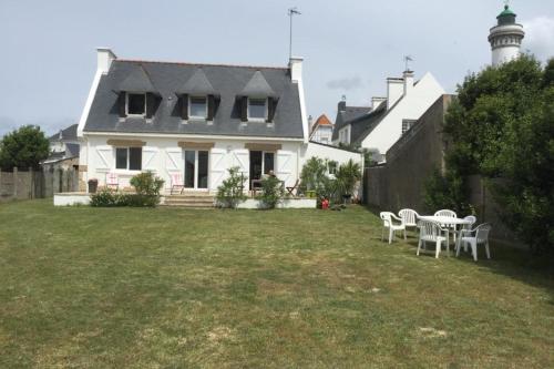 a white house with a table and chairs in the yard at Grande maison proche plage et centre ville avec grand parking in Quiberon