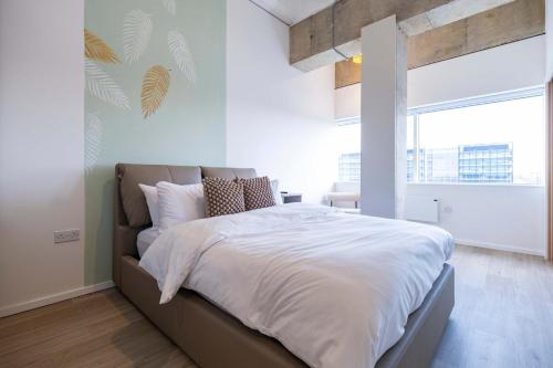 a bedroom with a large bed with white sheets at Station Gold Leaf - Gym - Games Room - MK in Milton Keynes