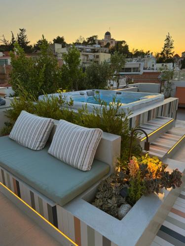 a bench on the roof of a building with jacuzzizers at Meros - Athenian Residencies in Athens