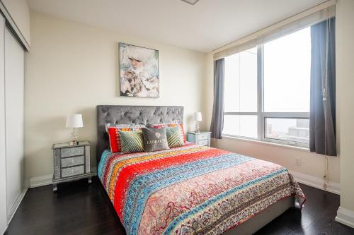 a bedroom with a bed and a large window at Modern 1 BR Apartment in North York Free parking in Toronto