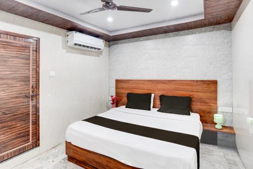 a bedroom with a large bed with a wooden headboard at Hotel O Govind Nagar Kanpur Formerly Maharoopa Palace in Kānpur