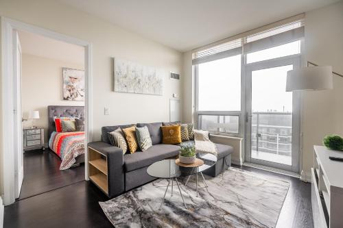 a living room with a couch and a table at Modern 1 BR Apartment in North York Free parking in Toronto