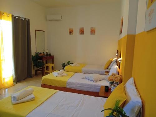 a room with two beds with yellow sheets at on the STRIP studio 3 in Kavos