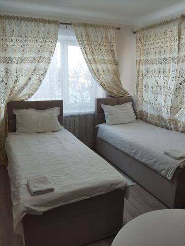 two beds in a room with a window at Sweet home in Tauragė