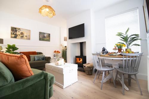 a living room with a couch and a table with a fireplace at Central Stamford Townhouse With Parking in Stamford
