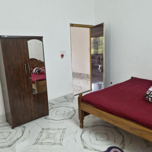 a bedroom with a bed and a mirror at shreejikunj in Bolpur