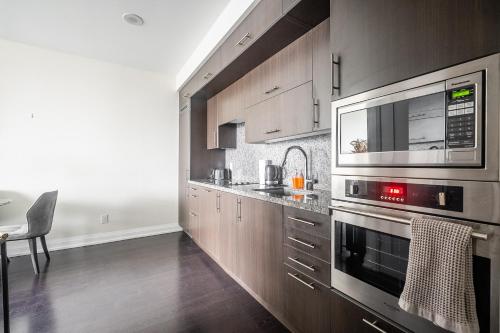 a kitchen with wooden cabinets and a microwave at Modern 1 BR Apartment in North York Free parking in Toronto