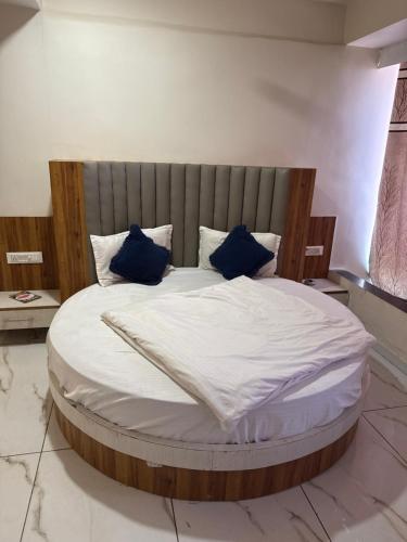 a large bed with blue pillows in a room at hotel belva in Ahmedabad