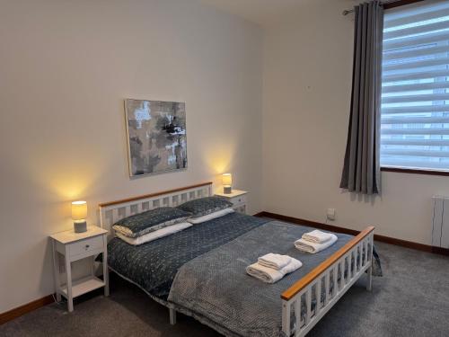 a bedroom with a bed with two towels on it at Ben Lomond Apartment - Macaulay Letting in Alexandria