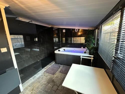 a bathroom with a tub and a table in it at Jacuzzi et Cinéma, Merignac2 in Mérignac