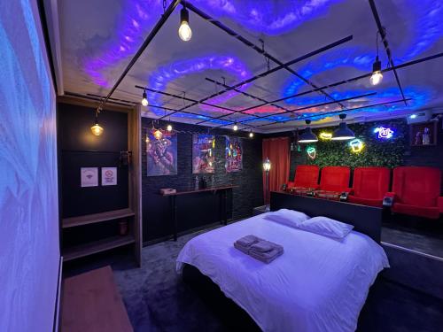 a bedroom with a bed with purple lights on it at Jacuzzi et Cinéma, Merignac2 in Mérignac
