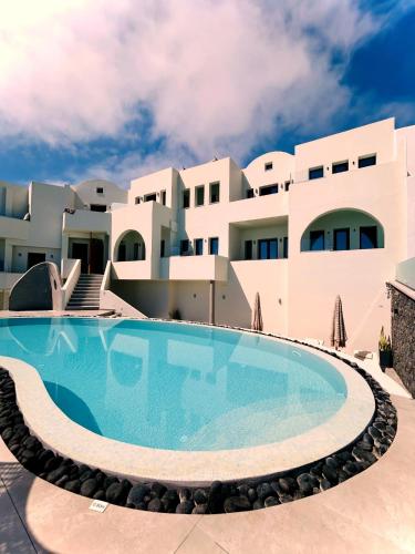 a swimming pool in front of a building at Kudos Suites Firostefani in Fira