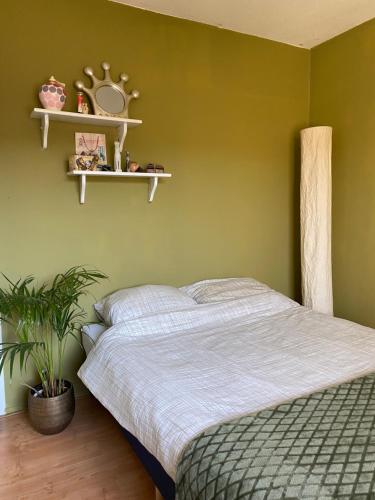 a bedroom with a bed and a green wall at Great House for Two in Amsterdam in Amsterdam