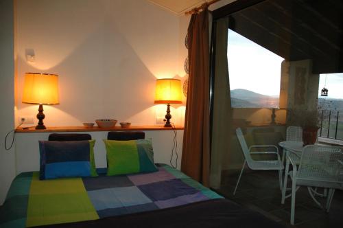 MontsonisにあるLoft con chimenea y terraza con vistasのベッドルーム1室(ベッド1台付)、バルコニー(テーブル付)