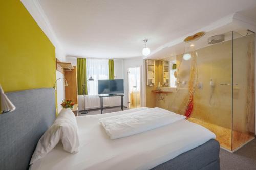 a bedroom with a white bed and a shower at Altötting City Apartments in Altötting
