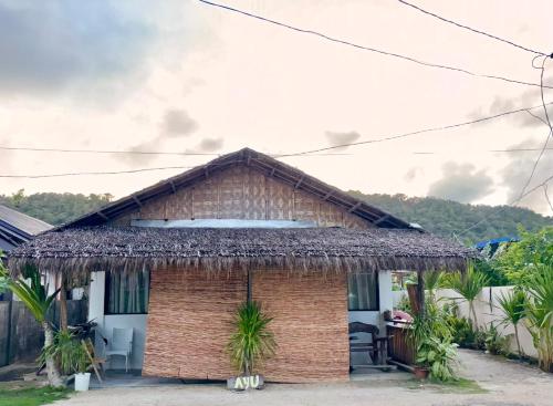 a small house with a thatched roof at Ayu Homestay - Room 4 in San Isidro