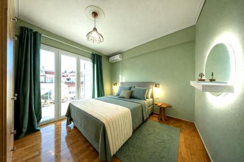 a bedroom with a bed and a large window at Olive Aura in Mytilene