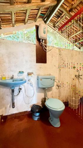 a bathroom with a toilet and a sink at This is it Stays - Beach View Rooms & Huts in Arambol
