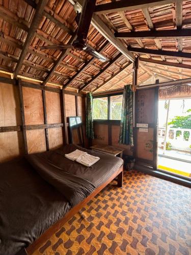 a bedroom with a bed in a room with windows at This is it Stays - Beach View Rooms & Huts in Arambol