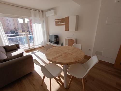 a living room with a table and chairs and a couch at La Ostra De Benidorm in Benidorm