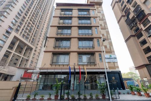 a tall building with flags in front of it at Treebo Alfa Suites in Mumbai