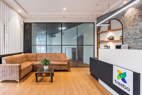 a living room with a couch and a table at Treebo Alfa Suites in Mumbai