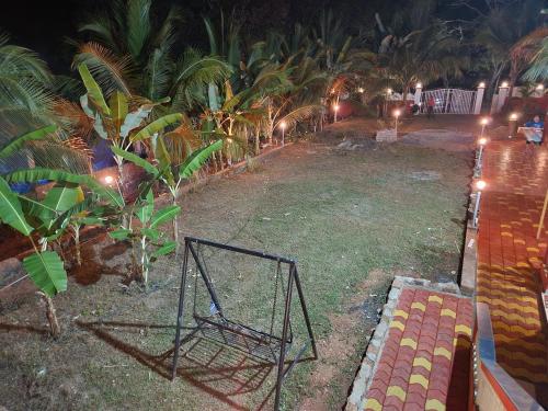a yard with a net in the grass with palm trees at Serene Green Park in Canacona
