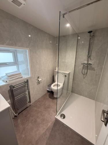 a bathroom with a toilet and a glass shower at The Carisbrooke in Forres