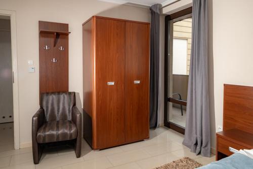 een slaapkamer met een stoel en een houten kast bij Villa Plena in Ośno Lubuskie