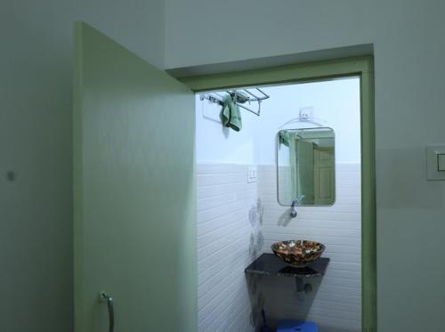 a bathroom with a sink and a mirror on the wall at Mannath lands end Beach house in Kaup