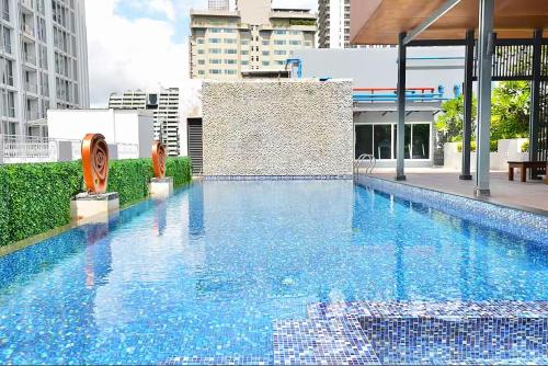 a large blue swimming pool on top of a building at Dazzle Residence Sukhumvit Bangkok in Bangkok