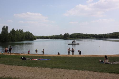 a group of people standing on the shore of a lake at Camping Au Coeur de Vendome in Vendôme