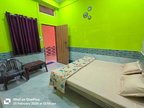 a bedroom with a bed and a chair and a door at Vraja Kishori Sewa Dham in Vrindāvan