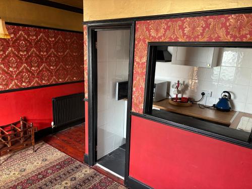 a room with a red wall and a room with a window at Keats Green Hotel in Shanklin