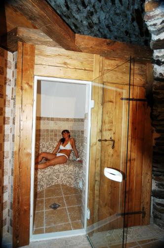 a woman sitting in a mirror in a bathroom at Residence Ca' Delle Margherite in Pellizzano