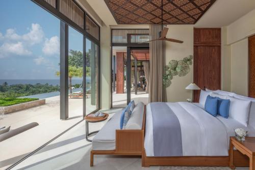 a bedroom with a large bed and a balcony at Anantara Layan Phuket Resort in Layan Beach