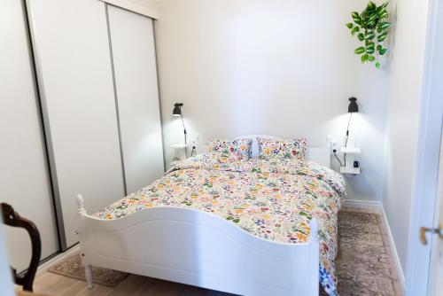 a white bed in a white bedroom with flowers at Toftenäs apartment in Toftenäs