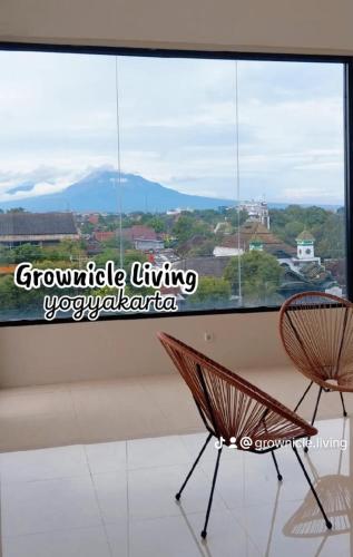 two chairs sitting in front of a large window at Grownicle Living Syariah in Yogyakarta