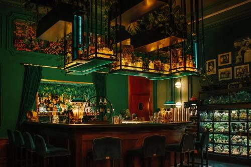 a bar in a restaurant with a green wall at Radisson Blu Carlton Hotel, Bratislava in Bratislava