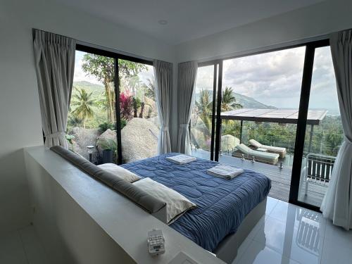 a bedroom with a bed and a large window at ON THE RoCK SEAVIEW in Ban Nua