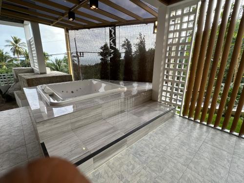 a jacuzzi tub in a room with large windows at ON THE RoCK SEAVIEW in Ban Nua