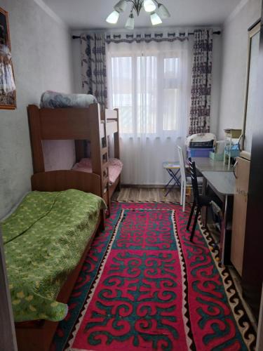 a room with a bed and a table and a rug at Mary's Home in Korumdy