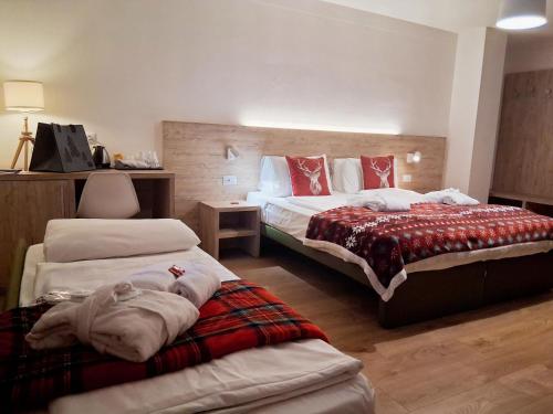 a hotel room with two beds and a bed at Hotel Kronplatzer Hof in Rasun di Sopra
