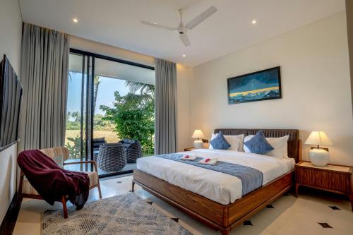 a bedroom with a large bed and a balcony at Hotel Claytone Near Delhi Airport in New Delhi
